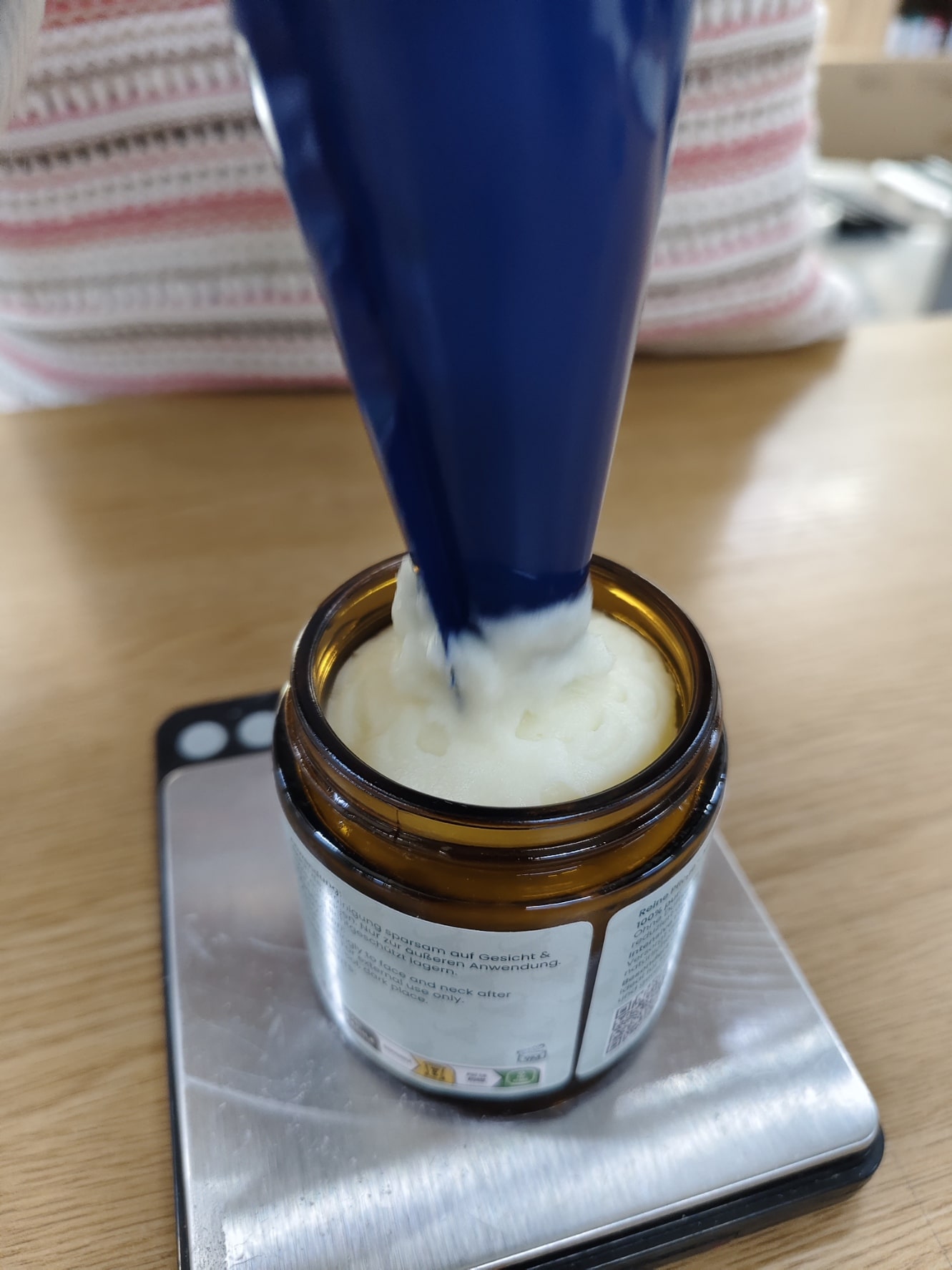 Tallow Natural wird mit einem Spritzbeutel in einen Braunglastiegel abgefüllt